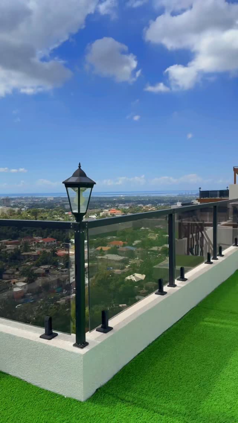 Tinted glass balcony railing with black hardware and Kingston view from the Exquisite Instagram feed.